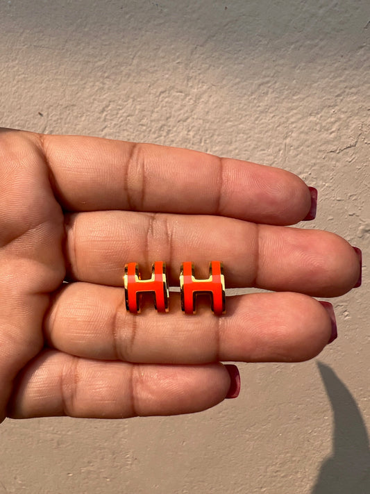Studs HERMES letra naranja